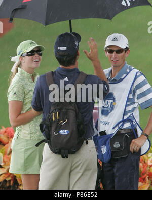 WEST PALM BEACH, FL - NOVEMBER 14, 2007: LPGA player Paula Creamer hides from a brief shower on the 14th tee  during the pro-am prior to the start of the ADT Championship at the Trump International Golf Club on November 14, 2007 in West Palm Beach, Florida   People:  Paula Creamer Stock Photo