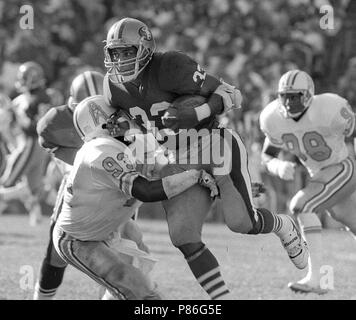 Pittsburgh Steelers running back Franco Harris (32) picks up 10 yards as he  turns the corner as Houston Oilers' Robert Brazile (52) makes a dive to  latch on to Harris to make