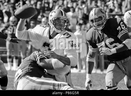 New Orleans Saints quarterback Bobby Hebert with his arm cocked back is  sacked by San Francisco 49ers defensive lineman Charles Haley during the  first quarter of their game at Candlestick Park in