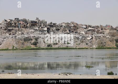 Mosul. 5th July, 2018. Photo taken on July 5, 2018 shows debris of the collapsed buildings in the old city of Mosul, Iraq. One year after the Iraqi forces liberated the city of Mosul from Islamic State (IS) militants, tens of thousands of displaced residents are still living in tents, suffering the scorching summer with a temperature of over 50 degrees Celsius. TO GO WITH Feature: One year on, tens of thousands of Iraqis remain displaced from homes in Mosul Credit: Khalil Dawood/Xinhua/Alamy Live News Stock Photo