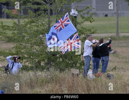 Stratford, London, UK. 10th July, 2018. People watch in the park and fly their RAF flag. Royal Air Force (RAF) 100 years celebration flypast. Queen Elizabeth Olympic Park. Stratford. London. UK. 10/07/2018. Credit: Sport In Pictures/Alamy Live News Stock Photo