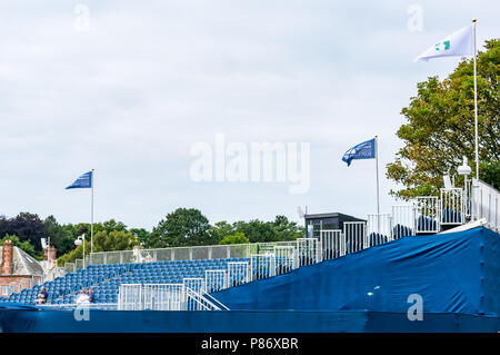 Gullane, UK. 10th July 2018. Aberdeen Standard Investments Scottish Open Golf Championship final preparations, Gullane, East Lothian, Scotland, United Kingdom, 10th July 2018. The final stages of preparations in progress for the 5th European Tour Rolex Series at Gullane Golf Course in preparation for the start of the championship from 12th to 15th July. A few spectators sit in the grandstand at the 18th watching the practise Stock Photo