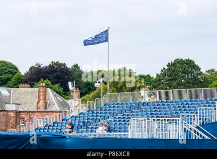 Gullane, UK. 10th July 2018. Aberdeen Standard Investments Scottish Open Golf Championship final preparations, Gullane, East Lothian, Scotland, United Kingdom, 10th July 2018. The final stages of preparations in progress for the 5th European Tour Rolex Series at Gullane Golf Course in preparation for the start of the championship from 12th to 15th July. A few spectators sit in the grandstand at the 18th watching the practise Stock Photo