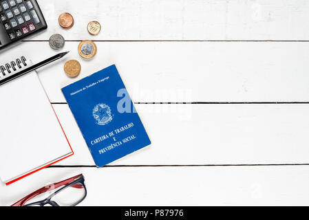 Work permit, calculator, notepad, black pencil, glasses and some Brazilian  coins on white background pinus Stock Photo