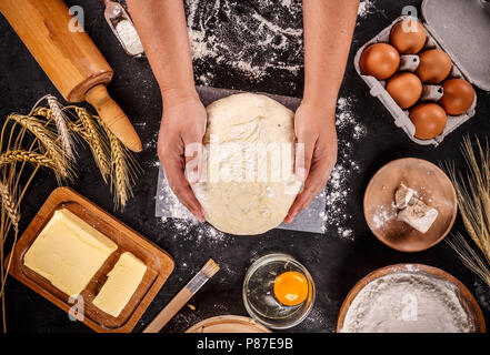 Dough background. Fresh dough with various ingredients on a black background Stock Photo