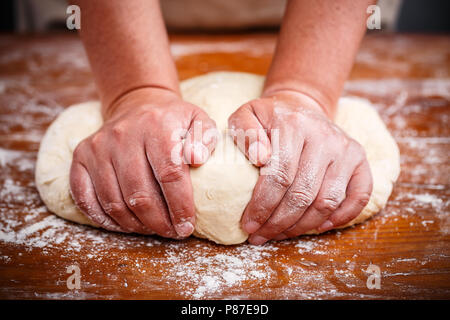 Female hands preparing dough for pizza on table closeup Stock Photo