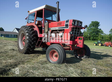 International Harvester model 1466 diesel Row Crop tractor in hay field Stock Photo