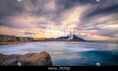 great sunset over zurriola beach, with the sun going down behing mount urgull Stock Photo