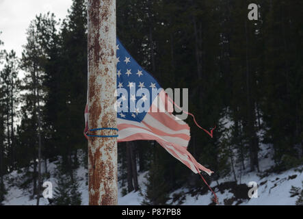 Wind and sun worn flag in Rocky Mountains Stock Photo