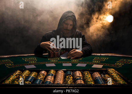 Portrait of a professional poker player sitting at pokers table Stock Photo