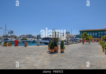 Limassol Marina, Cyprus - June 29, 2018: View of the new marina with paving in the foreground and cruise speed boats moored on a bright blue sky mid s Stock Photo