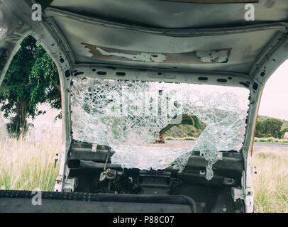Broken windscreen on abandoned car in countryside Stock Photo
