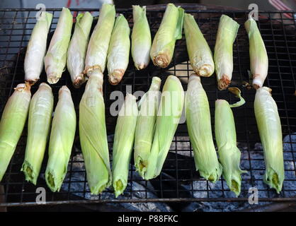 Baby corns are cooked on a charcoal grill Stock Photo