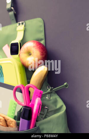 Backpack with school supplies on black background. Top view Flat lay Stock Photo