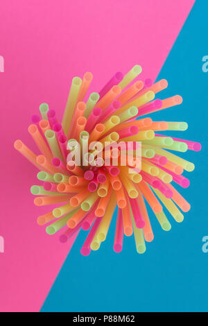Creative view of drinking straws(neon colors) party on a two-tone background - pink and blue. Top view. Stock Photo
