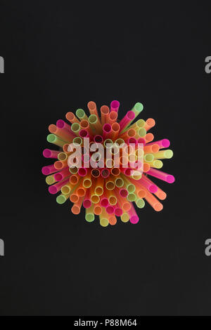 Creative view of drinking straws for party on black background in neon colors. Top view. Stock Photo