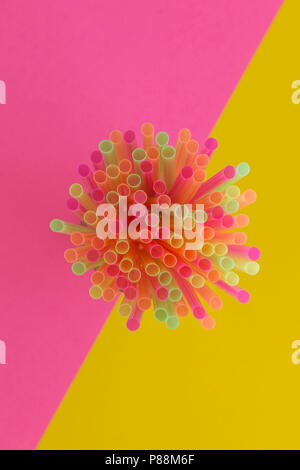 Creative view of drinking straws(neon colors) party on a two-tone background - pink and yellow. Top view. Stock Photo