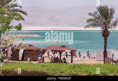 bathers and tourists enjoying a beach at Ein Bokek on the Dead Sea in Israel with Jordanian mountains in the background Stock Photo