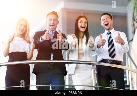 business team standing on the terrace and shows thumb up. Stock Photo