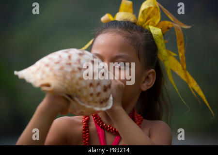 Young Girl playing a Conch Shell Stock Photo