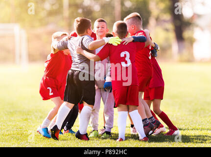 Kids soccer football - young children players celebrating after match on soccer field Stock Photo