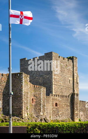 UK, Northern Ireland, Co Antrim, Carrickfergus, flag of Ulster flying beside Norman Castle Stock Photo