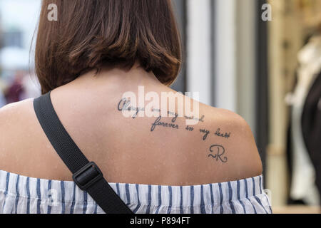 Tattoo of the words, always on my mind, forever in my heart, on young ladies rear shoulder, Lucca, Tuscany, Italy, Europe, Stock Photo
