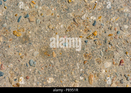 Closeup view of a concrete texture pattern with colorful pebbles or gravel stones inserted into the cement. Stock Photo