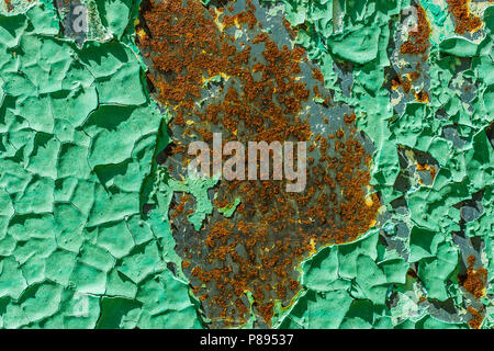 Old, rusty metal surface with peeled off and cracked green paint and layers of brown rust. Creative background or texture. Stock Photo