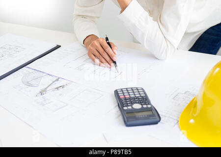 Close-up Of Person's engineer Hand Drawing Plan On Blue Print with architect equipment, Architects discussing at the table, team work and work flow co Stock Photo