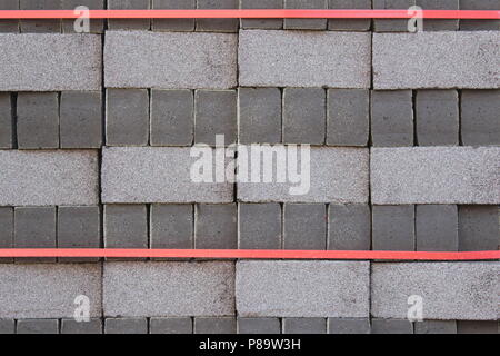 Grey new bricks stacked, ready to use for construction of a street or a building Stock Photo
