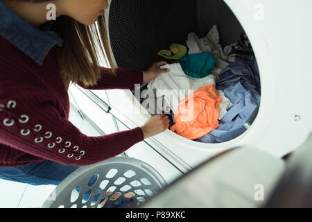 Woman doing laundry in laundromat Stock Photo