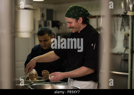 Male chefs preparing food in kitchen Stock Photo