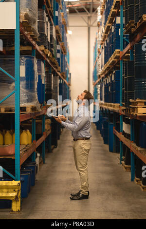 Male manager using laptop while checking stocks Stock Photo