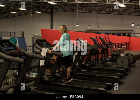 Mature woman exercising on treadmill in the gym Stock Photo