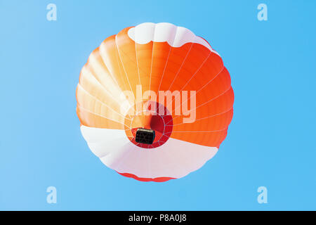 Colorful unbranded hot-air balloon flying in the background of blue sky, low angle picture Stock Photo