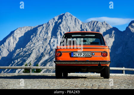 BMW 2002 tii, classic car on the Rossfeld panorama road, in the back the summit of the Hohe Göll, Berchtesgaden, Upper Bavaria Stock Photo