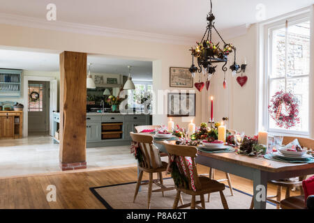Lit candles on dinding table in open plan dining room kitchen of Regency home Stock Photo