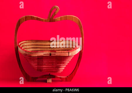 Decorative wooden lazer cut bread or fruit basket on pink background Stock Photo