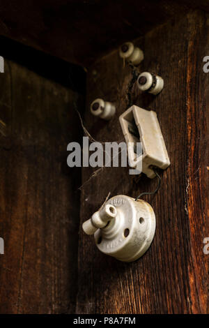 Detail close up of old ceramic electrical switch and fusebox on an old farm building in Liebro, Catalonia, Spain Stock Photo