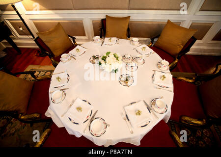 https://l450v.alamy.com/450v/p8a7tn/high-angle-shot-of-a-big-round-table-laid-with-an-english-afternoon-tea-table-setting-jam-and-a-flower-bouquet-on-a-white-table-cloth-in-a-p8a7tn.jpg