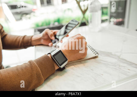 Young man wears smart watch working on table Stock Photo