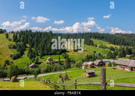 Beautiful countryside with neat rural houses standing on different sides of the road and farms with already cleaned and still lying dry hay. . For you Stock Photo