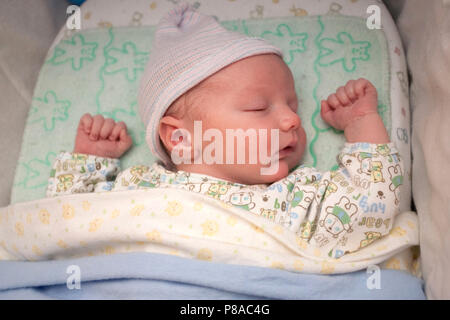 A new born takes a nap in his crib at home. Stock Photo