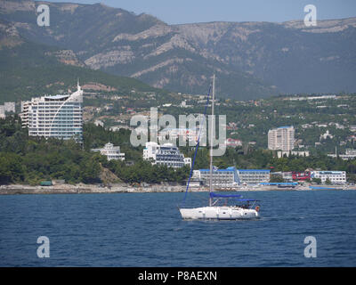 The yacht with a not raised sail whitens against the background of a blue, deep sea . For your design Stock Photo