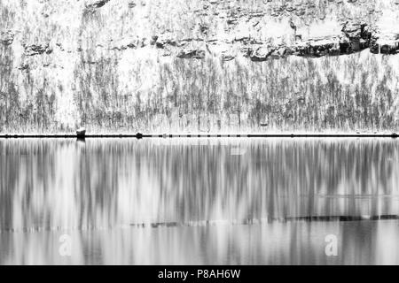 Abstract of snowcovered mountain in Arctic bay during winter, with reflection in water, Balsfjord, Norway