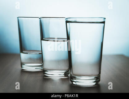 studio shot of three water glasses each one have more water than the other Stock Photo