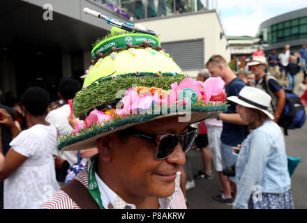 A spectator wearing a tennis themed hat on day eight of the Wimbledon Championships at the All England Lawn Tennis and Croquet Club, Wimbledon. Stock Photo