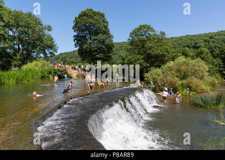 BATH, UK - JUNE 30, 2018 : People enjoying a hot day swimming at Warleigh Weir, a popular wild swimming spot near Claverton in Somerset. The summer he Stock Photo