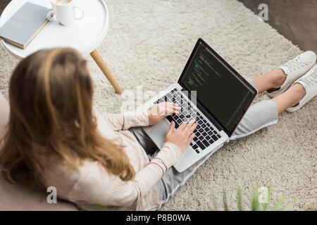 high angle view of young female developer coding with laptop at home Stock Photo
